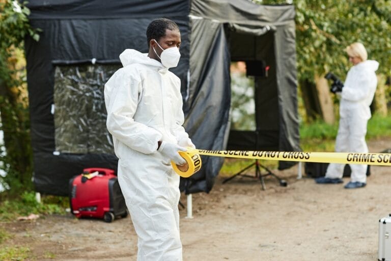 Black Man Unrolling Warning Tape with Do Not Cross Sign