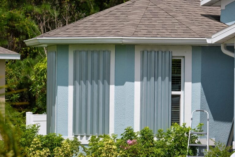 Boarded up windows with steel storm shutters for hurricane protection of residential house